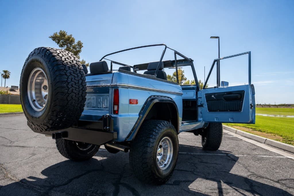 Side rear view of the Bronco with soft top and spare tire